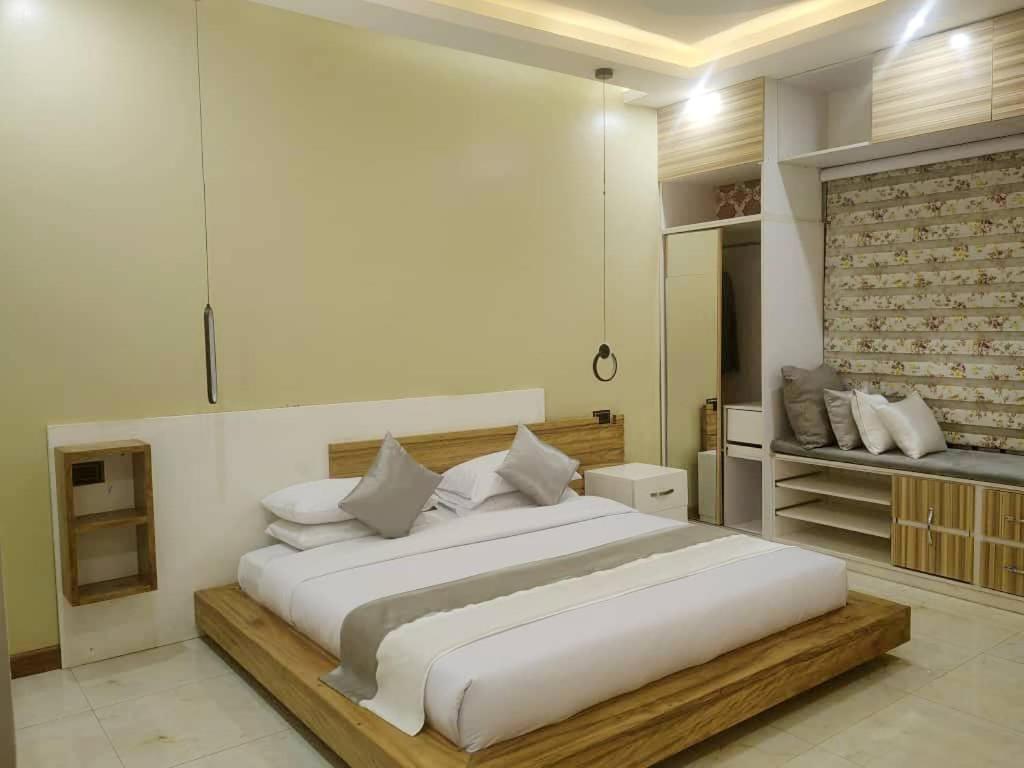 een slaapkamer met een groot wit bed in een kamer bij Lisa's 4 bedroom villa in Kampala