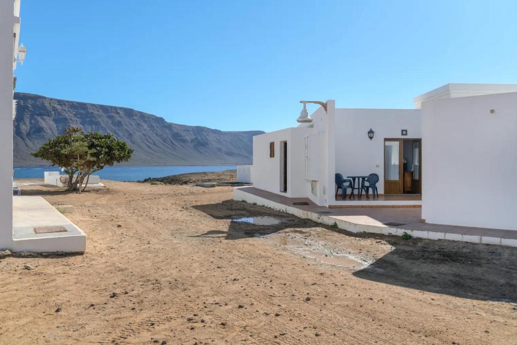 una casa bianca sulla riva di un corpo d'acqua di APARTAMENTOS FLOR a Caleta de Sebo