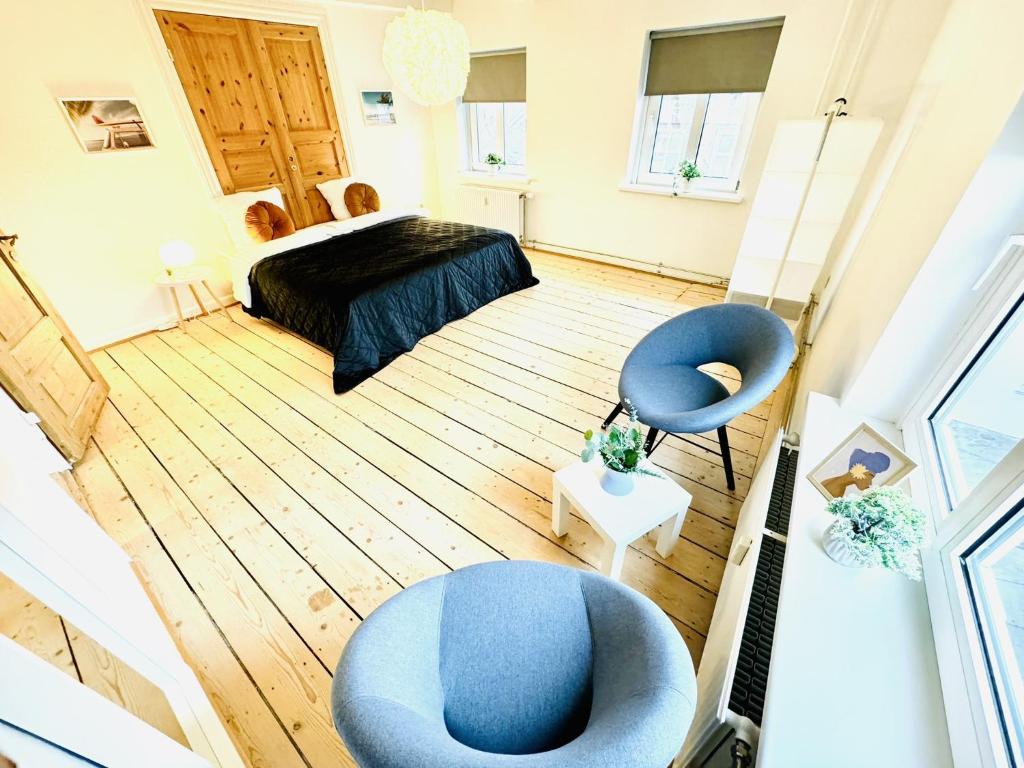 aday - Randers Beautiful Central 2 bedrooms Apartment في راندرس: غرفة نوم بها كرسيين ازرق وسرير