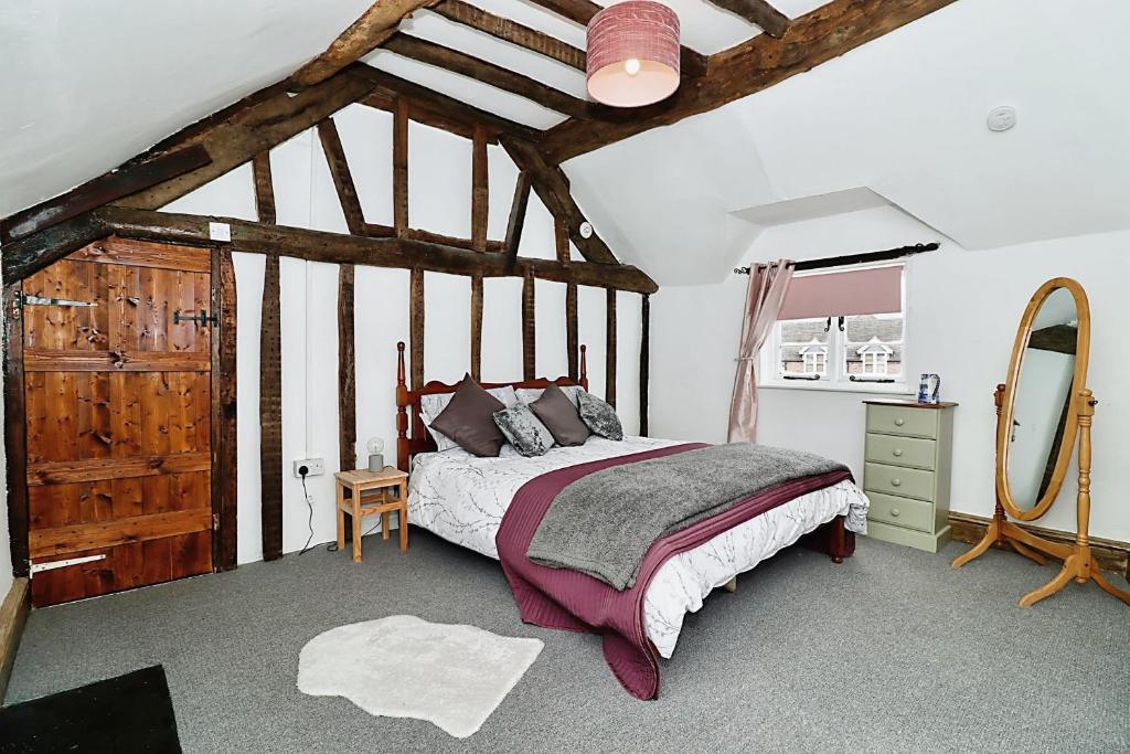 a bedroom with a bed and a dresser and a mirror at Milk & Honey Cottage 2 Bed Ironbridge Retreat in Broseley