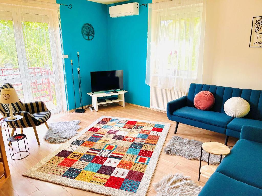 a living room with a blue couch and a rug at Király Családi Apartman- Royal Family Apartment in Budapest