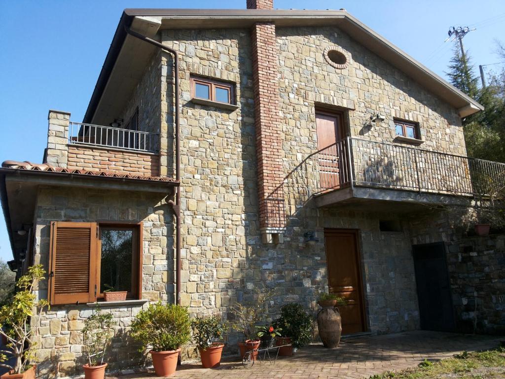 Casa de piedra con balcón y macetas en Agriturismo La Mancosa, en Pollica