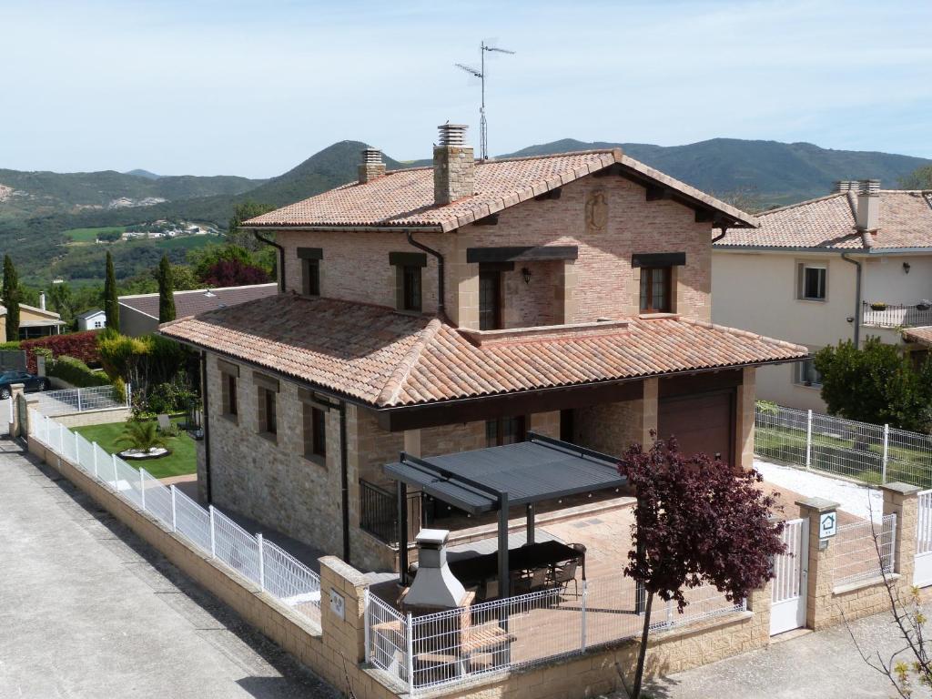 una casa in mattoni con tetto e balcone di Casa Rural Baigorri a Lácar