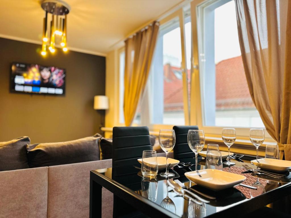 Un comedor con una mesa con copas de vino encima. en Keli Apartments Zentrum Oldenburg, en Oldenburg