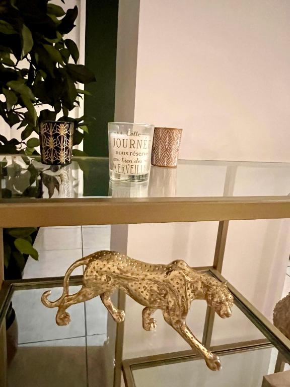 eine goldene Leopardenstaue auf einem Tisch mit einem Drink in der Unterkunft The Sunrise ~ Spacious, fully equipped &amp; parking in Montpellier