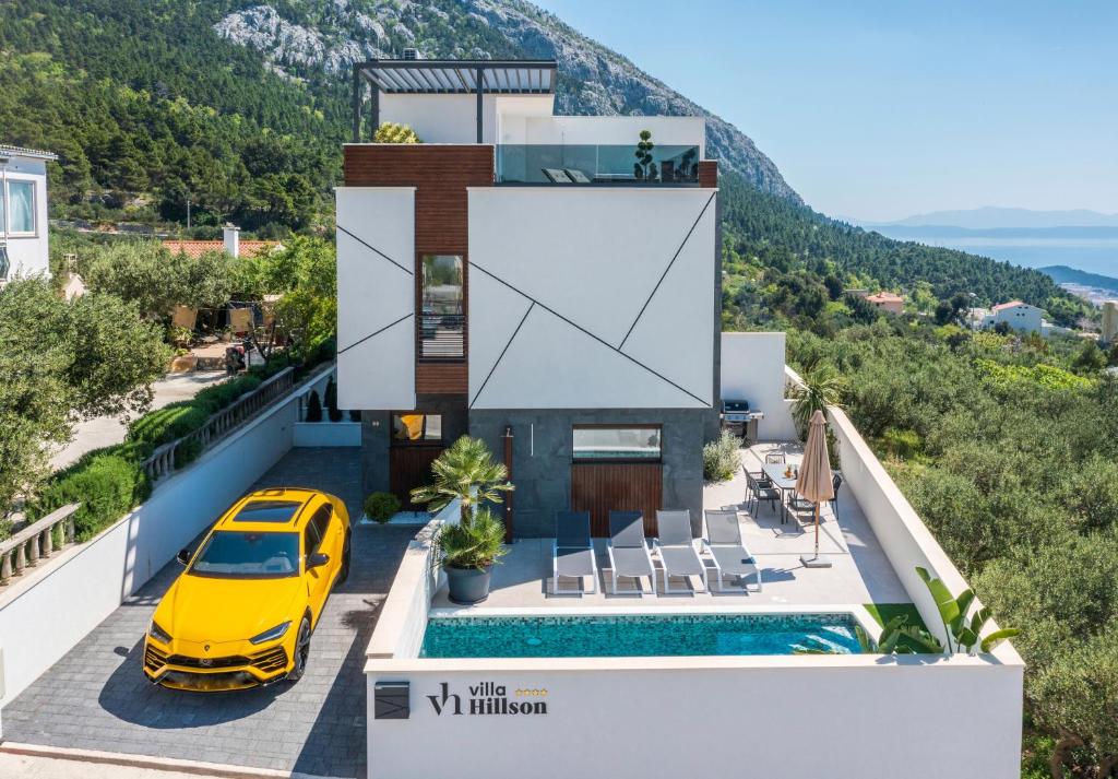 a house with a yellow car in front of it at Villa Hillson in Makarska