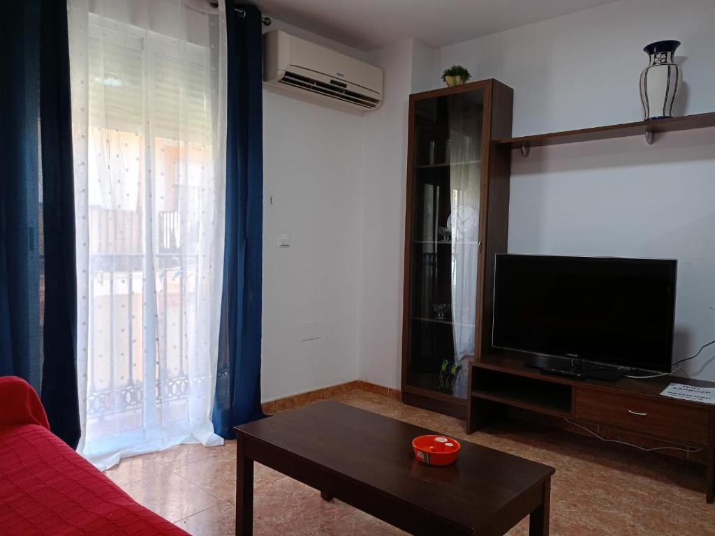 Una sala de estar con televisión y una mesa de café. en Apartamento carboneras y disfruta del LUJO del Parque Natural Cabo de Gata Nijar, en Carboneras