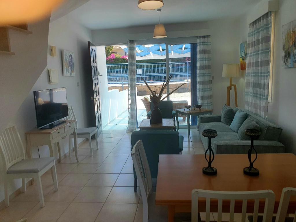 ein Wohnzimmer mit Sofa und Fernseher in der Unterkunft G&E HARBOUR MAISONETTE NUMBER 13 in Lachi