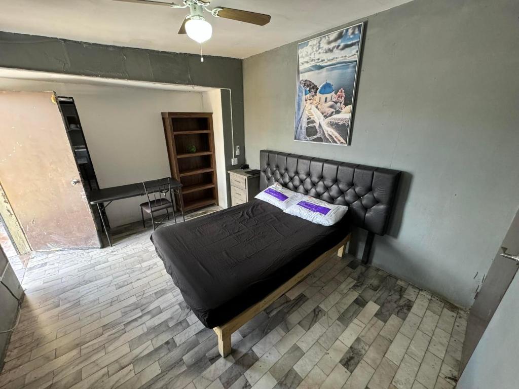 a bedroom with a black bed in a room at Loft economico cerca del puente Santa Fe in Ciudad Juárez