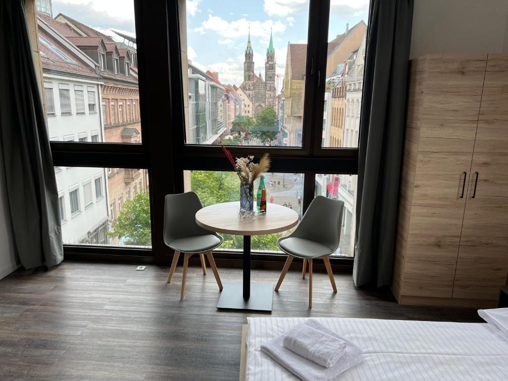 a table and chairs in a room with a large window at NB Apartments in Nürnberg
