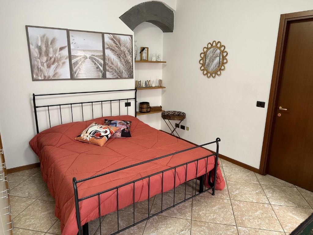een slaapkamer met een bed met een rode sprei bij La Casa di Mia in Bergamo
