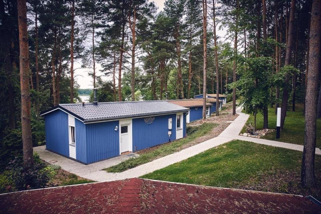 un pequeño edificio azul en medio de un bosque en Gemütliches Ferienhaus für bis zu 4 Personen-Urlaub machen, wo der Weihnachtsmann zu Hause ist, en Fürstenberg-Havel