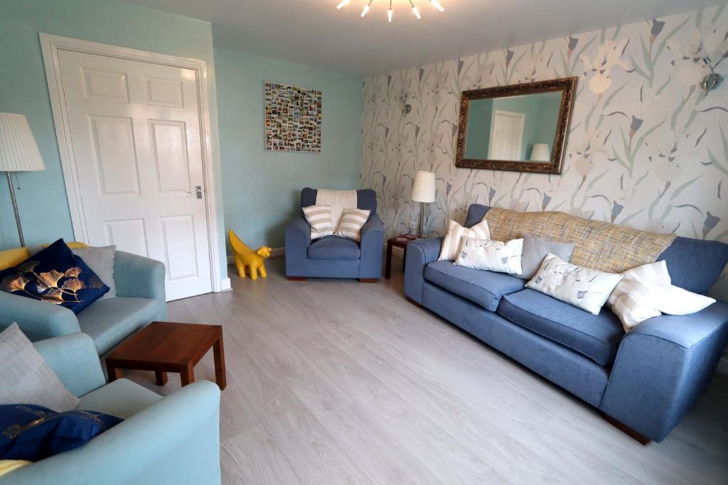 a living room with two blue couches and a mirror at In Our Liverpool Home Sleeps 5 in 2 Double & 1 Single Bedrooms in Liverpool