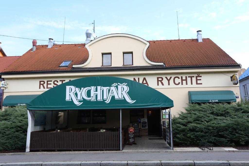 a restaurant with a green awning on a building at Pension & Restaurace Na Rychtě in Prague