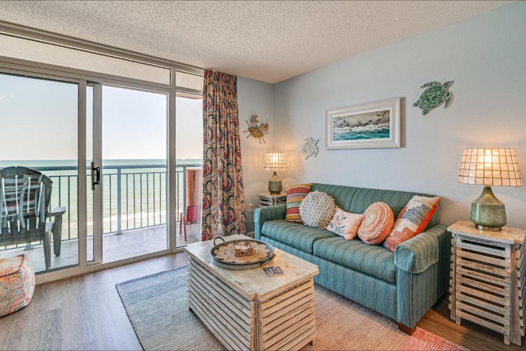 a living room with a couch and a balcony at Beachy Condo with Pool Access and Steps to Boardwalk! in Myrtle Beach