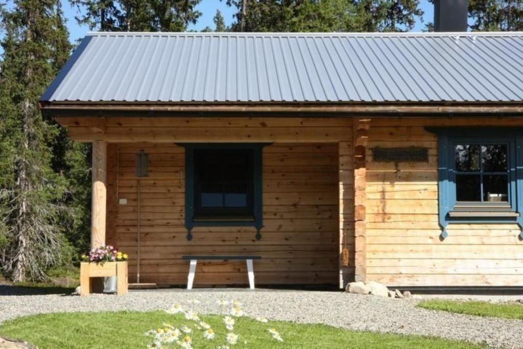 a log cabin with a bench in front of it at Gemütliches neu erbautes Blockhaus mit Kamin im Oviksfjäll in Galåbodarna