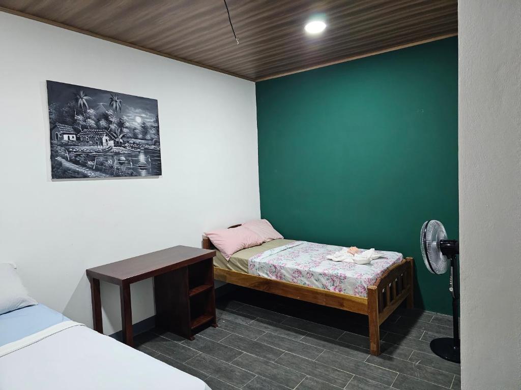 モヨガルパにあるHostal Mamá Derlysの小さなベッドと小さなテーブルが備わる客室です。