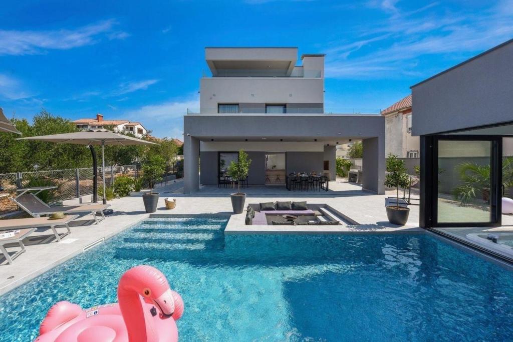a house with a swimming pool with a pink pig in front of it at Ferienhaus für 5 Personen und 1 Kind in Zadar, Dalmatien Zadar und UmUmgebung in Zadar