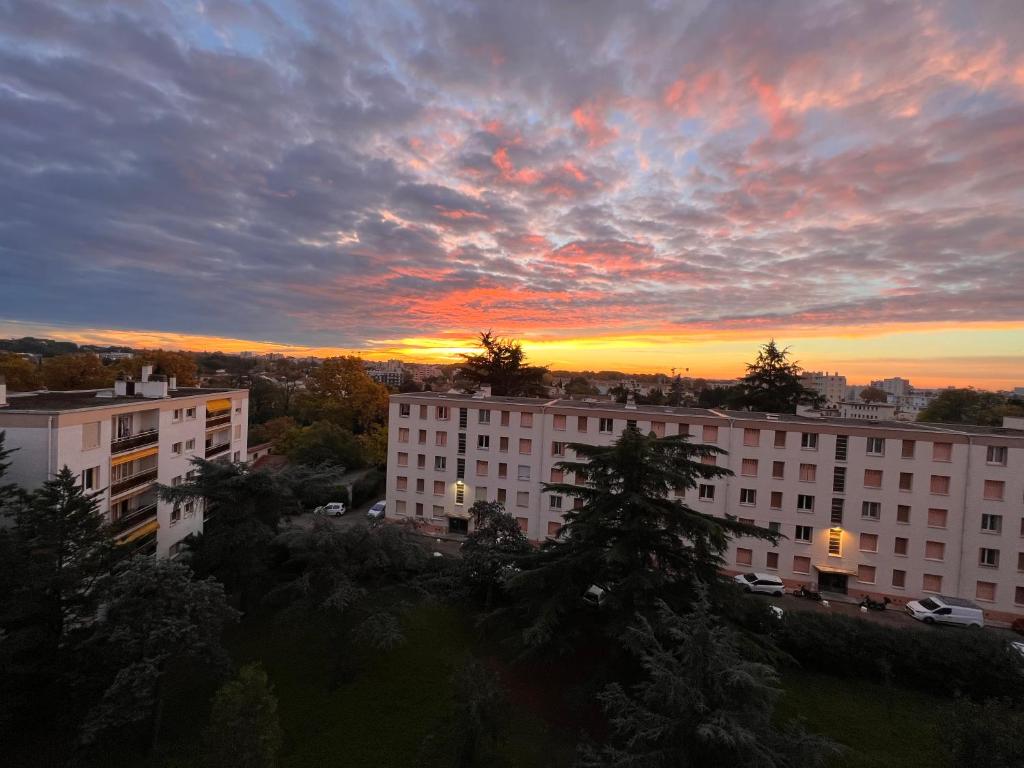 einen Sonnenuntergang in einer Stadt mit Gebäuden und Bäumen in der Unterkunft The Sunrise ~ Spacious, fully equipped &amp; parking in Montpellier