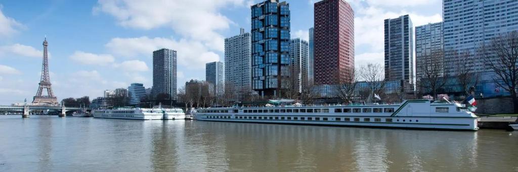 Deux bateaux sont amarrés dans une rivière d'une ville dans l'établissement Appartement de charme pour les JO 2024, à Paris