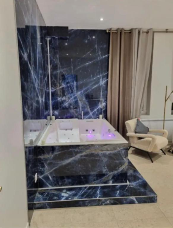 - une salle de bains pourvue d'une baignoire dans l'établissement Love Room stéphanoise, à Saint-Étienne