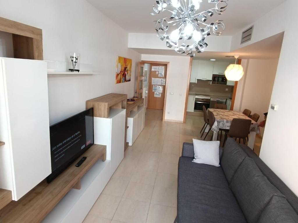 a living room and kitchen with a couch and a television at Piso Andrea in Lloret de Mar
