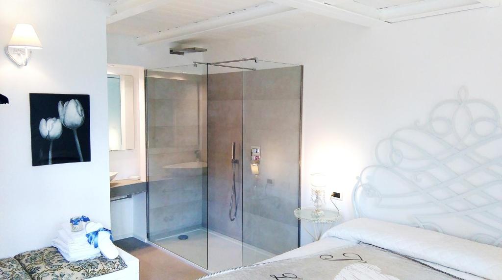- une chambre avec une douche et une porte en verre dans l'établissement La Maison di Bologna, à Bologne
