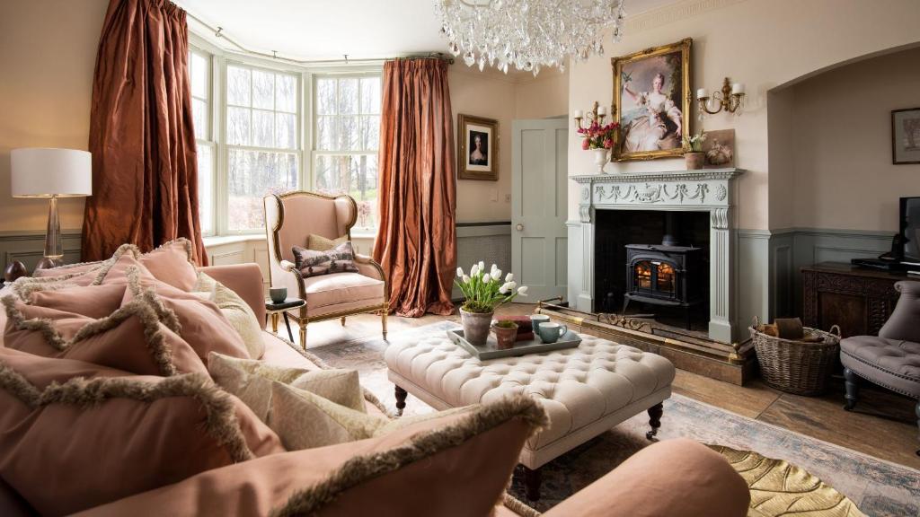 a living room with a couch and a fireplace at South Lodge, Twizell Estate in Belford