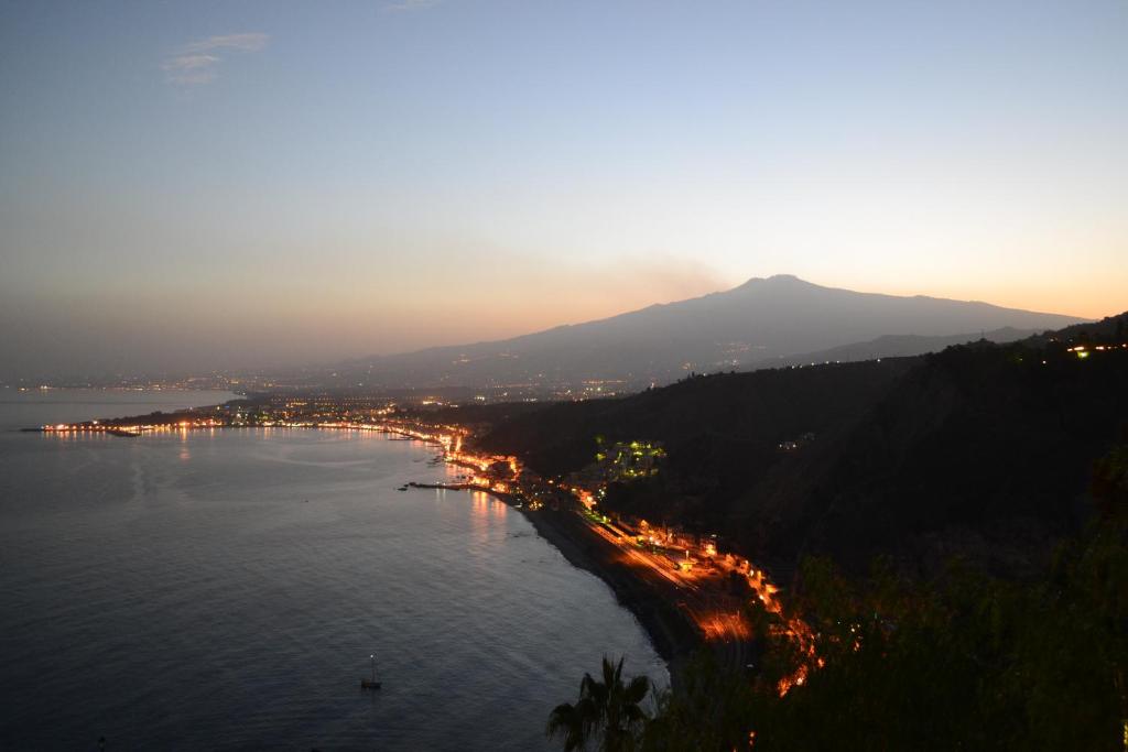 uma vista para uma baía com uma cidade e uma montanha em B&B Casa Margherita em Taormina