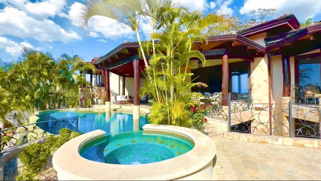 uma casa com piscina em frente a uma casa em Villa Durazno em Guanacaste