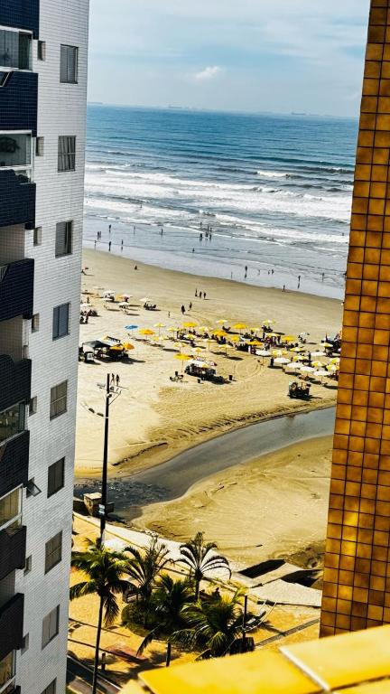 - une vue sur une plage avec des parasols et l'océan dans l'établissement Vila Mirim - Mendes House, à Praia Grande