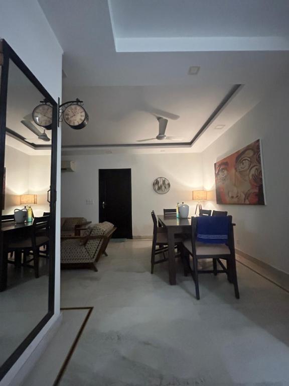 Home Away Home ( East Of Kailash ) New Delhi في نيودلهي: غرفة معيشة مع طاولة وكراسي