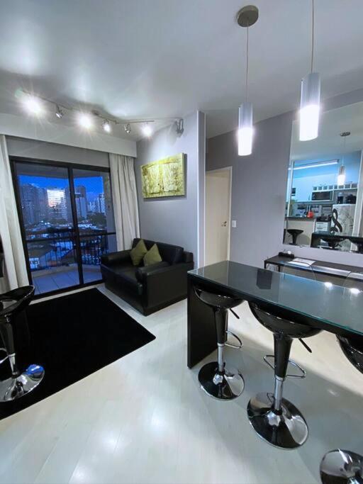 Hotel Apartamento Completo Business Comfort Home Office,Ar condicionado Quente e Frio, Estação de Trabalho, 7 min do Consulado Americano, WiFi 500MB, a living room with a table and a couch at Apartamento Completo Business Comfort Home Office,Ar condicionado Quente e Frio, Estação de Trabalho, 7 min do Consulado Americano, WiFi 500MB in São Paulo