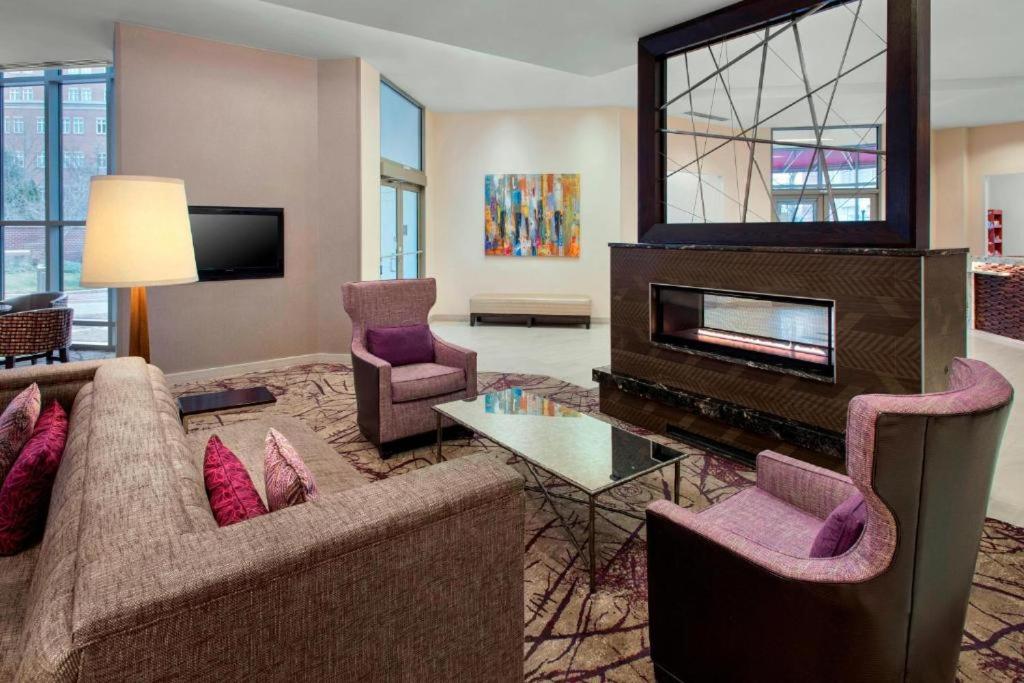 Residence Inn في الإسكندرية: غرفة معيشة مع أريكة ومدفأة