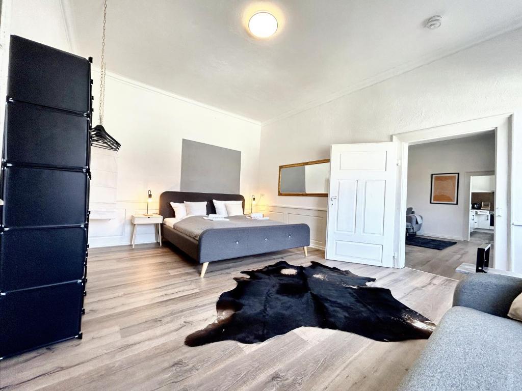 Schlafzimmer mit einem Bett und einem schwarzen Teppich in der Unterkunft BackHome - Fantastische Schlosslage, SmartTV, Netflix, 70qm, 24h Checkin - Apartment 2 in Ludwigsburg
