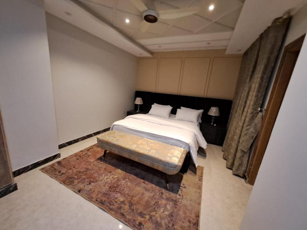 sypialnia z łóżkiem i ławką w obiekcie Sabs Residences w mieście Islamabad