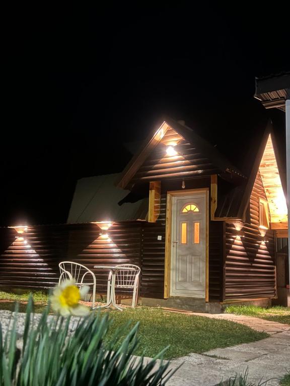une maison avec deux chaises et une porte la nuit dans l'établissement Apartment & Rooms Sweet Dreams, à Žabljak