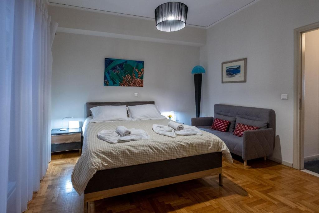 - une chambre avec un lit et un canapé dans l'établissement Oro's Stylish Kolonaki Flats Next to Metro & Museums, à Athènes