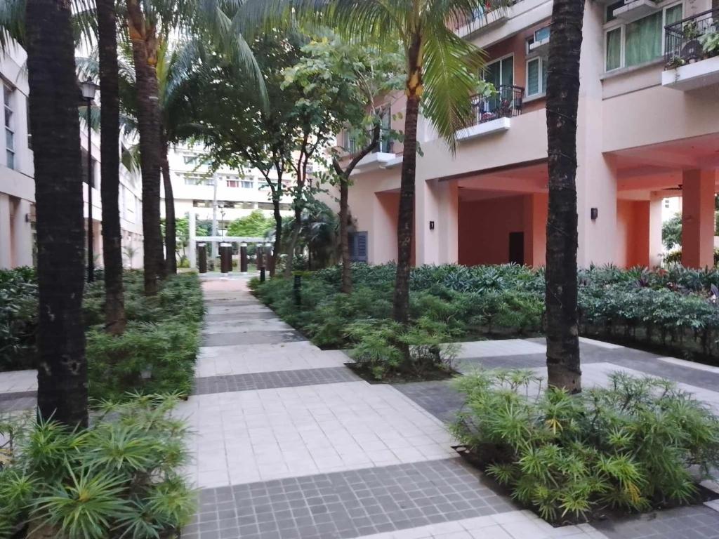 a sidewalk in front of a building with palm trees at Longterm Stay Only in Manila