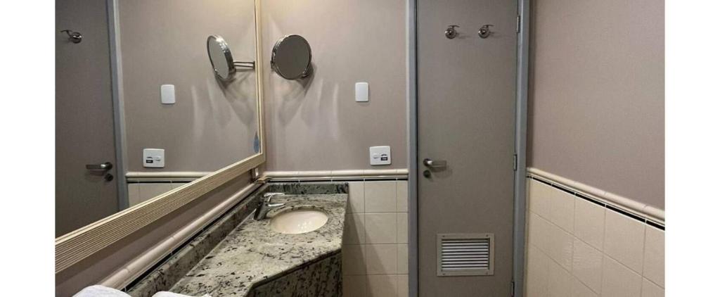 a bathroom with a sink and a mirror at Getaflat-1504 Berrini 4 estrelas in São Paulo
