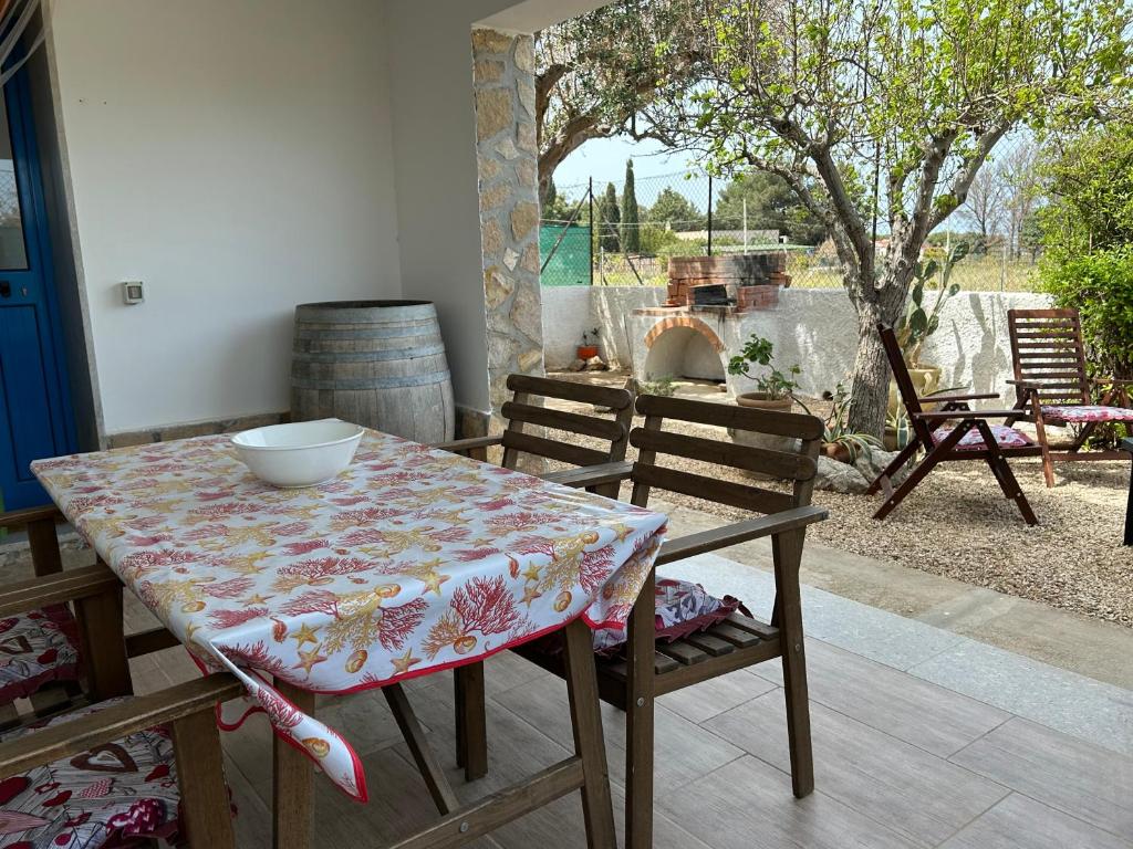 una mesa y sillas con un tazón encima en CASE PUNTA MONACO - Appartamenti con wi-fi e parcheggio privato gratuito, en San Vito lo Capo