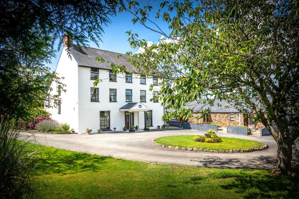 uma grande casa branca com uma entrada em East Hook Farmhouse em Haverfordwest