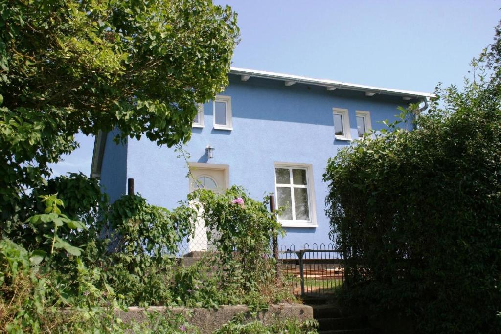 una casa azul con una valla delante de ella en Ferienhaus mit Terrasse und Kamin, en Karnin
