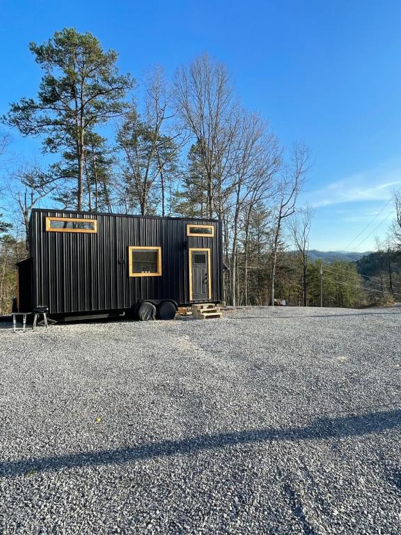 a black shipping container sitting on the side of a road at The Tennessee Tiny House in Sevierville