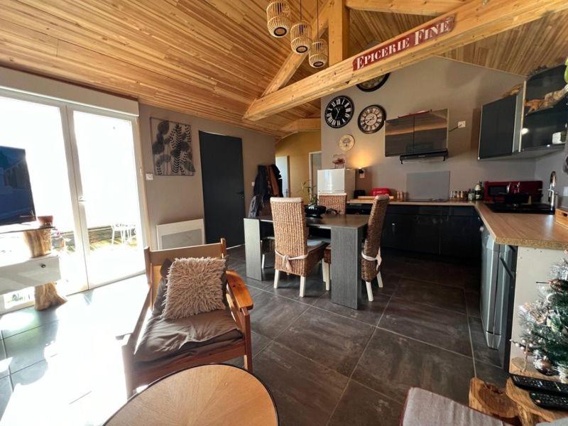 uma cozinha e sala de estar com mesa e cadeiras em Petite maison de vacances em Notre-Dame-de-Monts