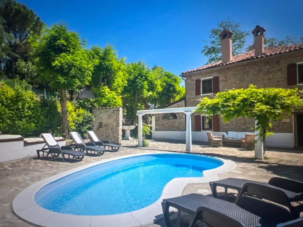 a swimming pool with chairs and a house at Familly Villa 4 Bedroom Sunrise in Rimini