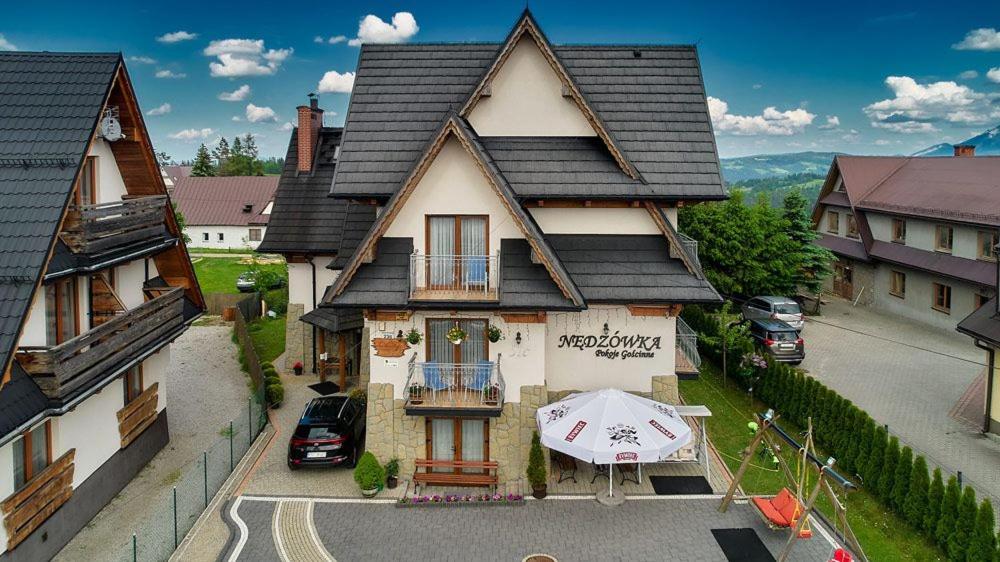 a house with an umbrella in front of it at Nędzówka in Ząb
