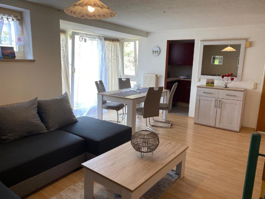 a living room with a couch and a table at Studio-Ferienhaus mit Gartenumzäunung für Hunde in Zandt