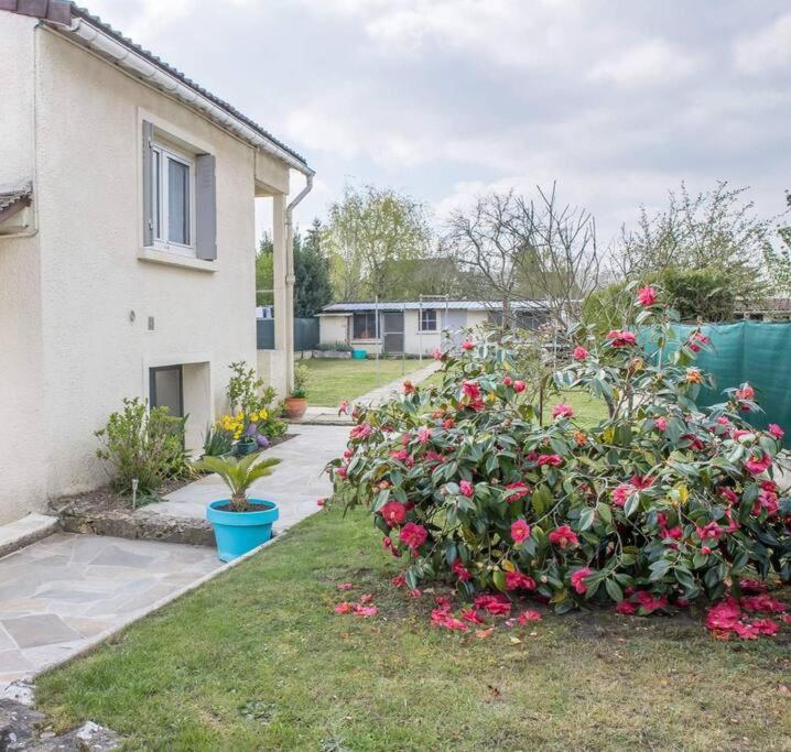 un jardín de rosas frente a una casa en Le studio, en Bonzac