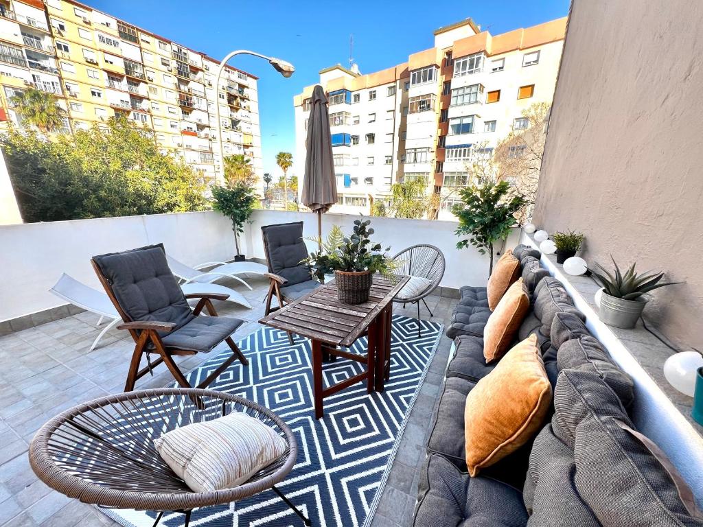 a patio with a couch and chairs on a balcony at New Fantastic Duplex with Terrace in Málaga